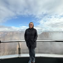 Jennifer at a glass-railed Grand Canyon overlook