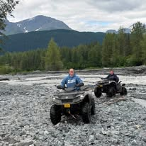 Jennifer and Jeremy on ATVs beside a river on the Historic Iditarod Trail in Alaska